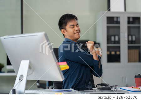 Male businessman is doing a stretchy posture due to sitting in the office for too long, office syndrome concept. 126752370