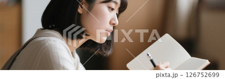 本を読みながらメモを取る女子大学生 本を読みながらメモを取る女子大学生 126752699
