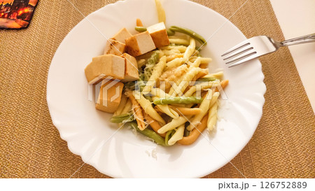 Strozzapreti pasta with tofu and green beans on white plate 126752889