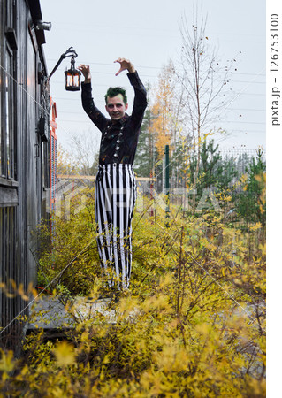 A jester embracing autumn vibes in colorful striped pants, full of joy and cheer A jester embracing autumn vibes in colorful striped pants, full of joy and cheer 126753100