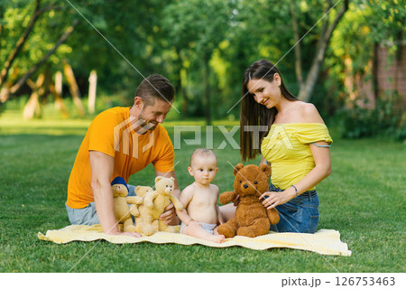 Family Playing With Teddy Bears Outdoors On Blanket Family Playing With Teddy Bears Outdoors On Blanket 126753463