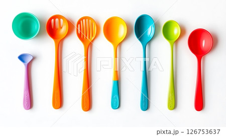 A row of colorful spoons and a bowl are shown on a white background 126753637