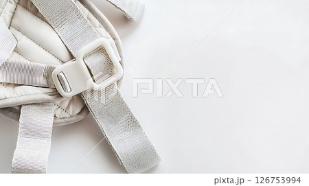 A strap is attached to a baby carrier 126753994