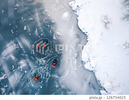 Three people ice fishing on a frozen lake. They wear bright orange jackets. Snow covers the surrounding area. The scene captures winter sports and outdoor activities. 126754025
