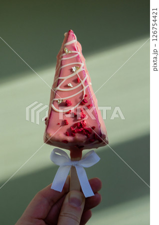 New look of trendy miniature ice cream cheesecake on stick in vibrant pink color on pastel background. Copy space mock up template sample for bakery mini dessert coffee shop. Cake to go takeaway sweet New look of trendy miniature ice cream cheesecake on stick in vibrant pink color on pastel background. Copy space mock up template sample for bakery mini dessert coffee shop. Cake to go takeaway sweet 126754421