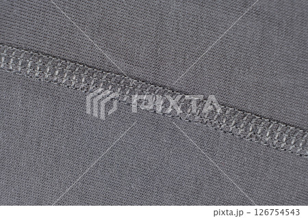 Macro texture of gray fabric consisting of cotton with a slight addition of elastane. Stitching with threads 126754543