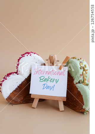 International bakery day greeting card Delicious fresh croissant topped with colorful flavor Ganache. Creation unique heart shape bakery. Puff pastry holiday love gift present idea 126754558