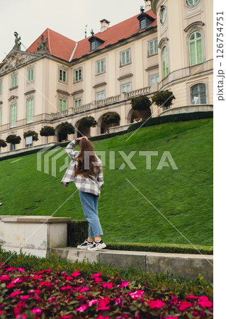 Female woman traveler sightseeing vacation holiday concept Beautiful violet flowers Castle Gardens on background adjacent to the Royal Castle in Warsaw from the side of the Vistula. Tourist attraction Female woman traveler sightseeing vacation holiday concept Beautiful violet flowers Castle Gardens on background adjacent to the Royal Castle in Warsaw from the side of the Vistula. Tourist attraction 126754751