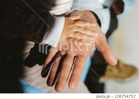 Child's Hand Resting on Parent's Hand in Tender Moment 126754757