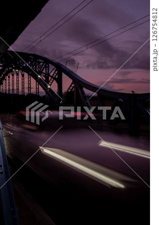 Defocused Lights of cars at night in Krakow bridge. Street line lights. Night highway city. Long exposure photograph night road. Colored bands of red light trails on the road. Background wallpaper  126754812