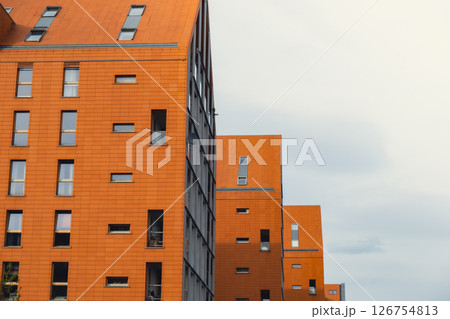 Modern office building exterior with glass facade on clear sky background. Transparent glass wall of office building with yellow decoration. Element of facade of modern European building Commercial 126754813