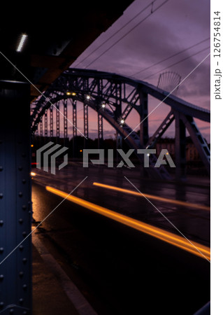 Defocused Lights of cars at night in Krakow bridge. Street line lights. Night highway city. Long exposure photograph night road. Colored bands of red light trails on the road. Background wallpaper  126754814