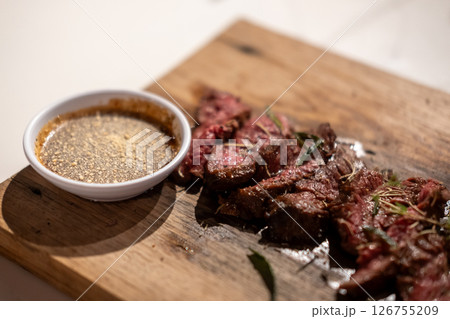 Medium rare sliced fried meat on wooden plate 126755209