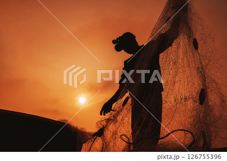 Silhouette of a Vietnamese male fisherman taking out a catch of fish from fishing net in boat on beach by the sea in a fishing village in the morning at sunrise in Vietnam Silhouette of a Vietnamese male fisherman taking out a catch of fish from fishing net in boat on beach by the sea in a fishing village in the morning at sunrise in Vietnam 126755396