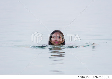 young asian woman enjoying swimming and smiling in shallow water of sea 126755584