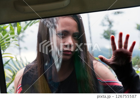 young woman looking inside car through window pressing palm to glass, view from inside car young woman looking inside car through window pressing palm to glass, view from inside car 126755587