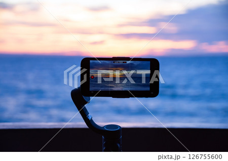 Smartphone filming a sunset over the ocean 126755600