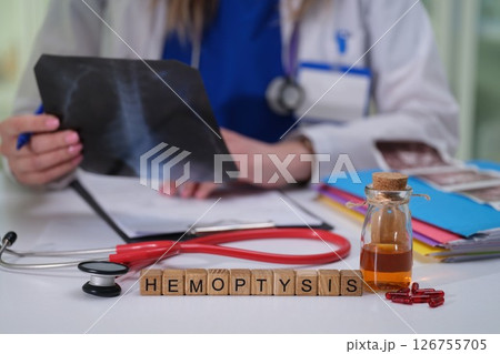 Doctor Conducting a Detailed Analysis of Hemoptysis Case Using Xray and Various Medical Tools 126755705