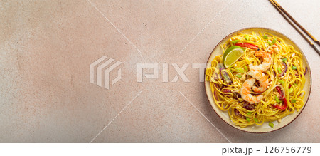 Pad thai noodles with shrimps, peanuts and lime on a plate, traditional dish of Thailand, space for text Pad thai noodles with shrimps, peanuts and lime on a plate, traditional dish of Thailand, space for text 126756779