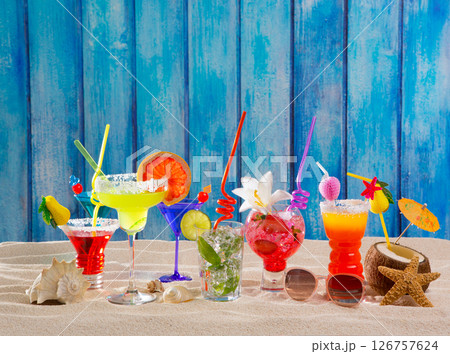 Colorful tropical cocktails at beach on blue wood wall 126757624