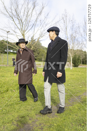Two senior men walking and talking in a park 126757729