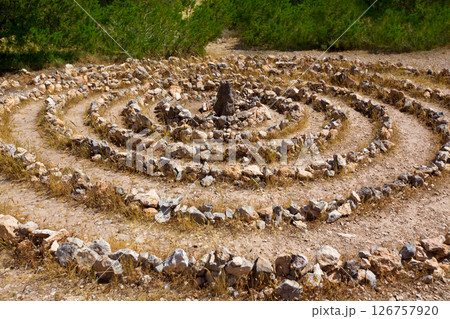 Atlantis spiral sign in Ibiza with stones on soil 126757920