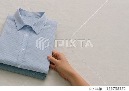 Stack of folded shirts on store table, showcasing clothes sale 126758372