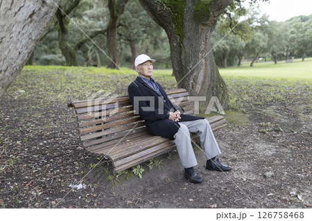 Senior man relaxing on park bench enjoying nature Senior man relaxing on park bench enjoying nature 126758468