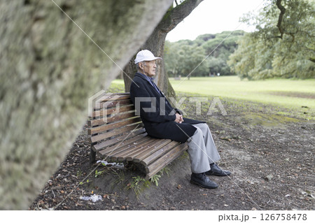 Senior man relaxing on park bench enjoying nature 126758478