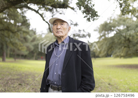 Senior asian man listening music with earphones in park 126758496