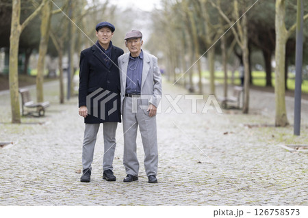 Asian father and son posing together in park Asian father and son posing together in park 126758573