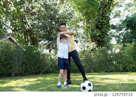 Wellness in Family Time: Father teaching son soccer skills outdoors Wellness in Family Time: Father teaching son soccer skills outdoors 126759718
