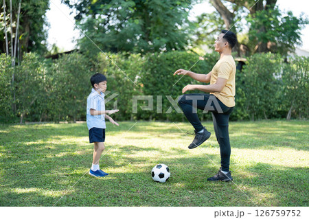 Wellness in Family Interaction: Father and son practicing soccer outdoors 126759752