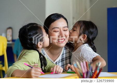Back to School. Affectionate moment between a teacher and her students during art class. 126759900