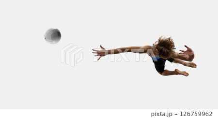 Aerial view of young athletic man, volleyball player dives in full stretch with arm forward to hit ball mid-air against white studio background Aerial view of young athletic man, volleyball player dives in full stretch with arm forward to hit ball mid-air against white studio background 126759962