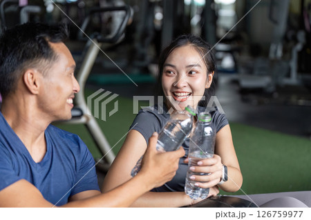 Wellness and Friendship. Friends enjoying hydration break after workout at the gym. 126759977
