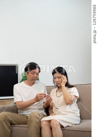 Wellness and Care. Elderly couple discussing health while sitting on a sofa. 126759988