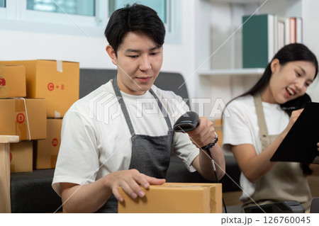 Couple managing inventory with barcode scanning in a modern workspace. Couple managing inventory with barcode scanning in a modern workspace. 126760045