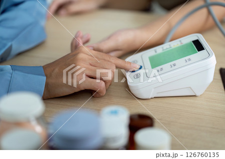Healthcare Monitoring. Nurse checking blood pressure with digital device on patient. 126760135