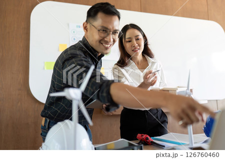 Sustainability and Innovation. Engineers discussing renewable energy solutions in a collaborative workspace. Sustainability and Innovation. Engineers discussing renewable energy solutions in a collaborative workspace. 126760460