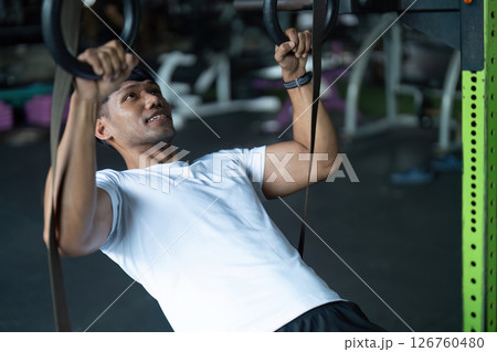 Strength Training: Young Man Engaging in Pull-Up Exercise 126760480