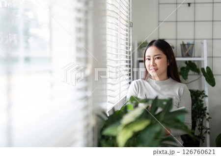Contemplation and Focus. Young woman reflecting in a bright home office. Contemplation and Focus. Young woman reflecting in a bright home office. 126760621