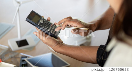 Sustainability and Engineering. Engineer using calculator for sustainable project analysis. Sustainability and Engineering. Engineer using calculator for sustainable project analysis. 126760638