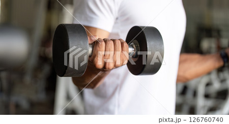 Dumbbell Workout. Man lifting dumbbell in gym for strength training. 126760740