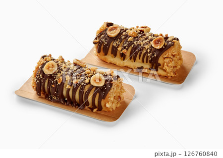 Two hazelnut and chocolate covered mini cakes resting on cardboard trays Two hazelnut and chocolate covered mini cakes resting on cardboard trays 126760840