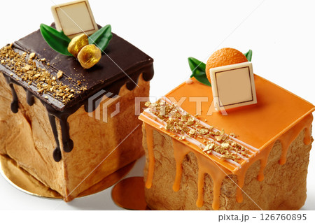 Delicious braun family pastry cubes dripping with chocolate and orange icing 126760895
