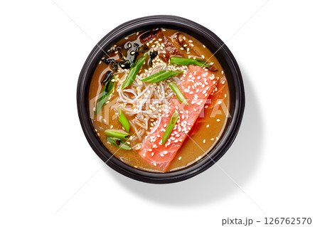Japanese miso soup with salmon, noodles, sesame seeds and green onions in black bowl Japanese miso soup with salmon, noodles, sesame seeds and green onions in black bowl 126762570