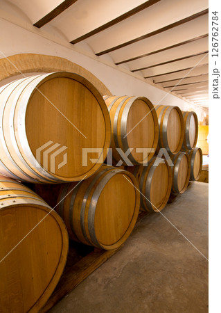 wine wooden oak barrels stacked in a row at winery 126762784