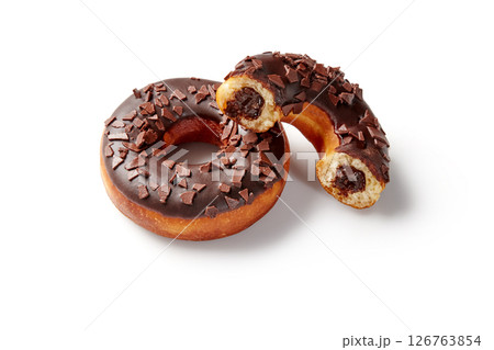 Two chocolate donuts with chocolate filling and shavings on white background Two chocolate donuts with chocolate filling and shavings on white background 126763854