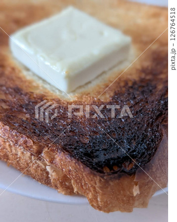 焦げたトーストにバターをのせた朝食 焦げたトーストにバターをのせた朝食 126764518
